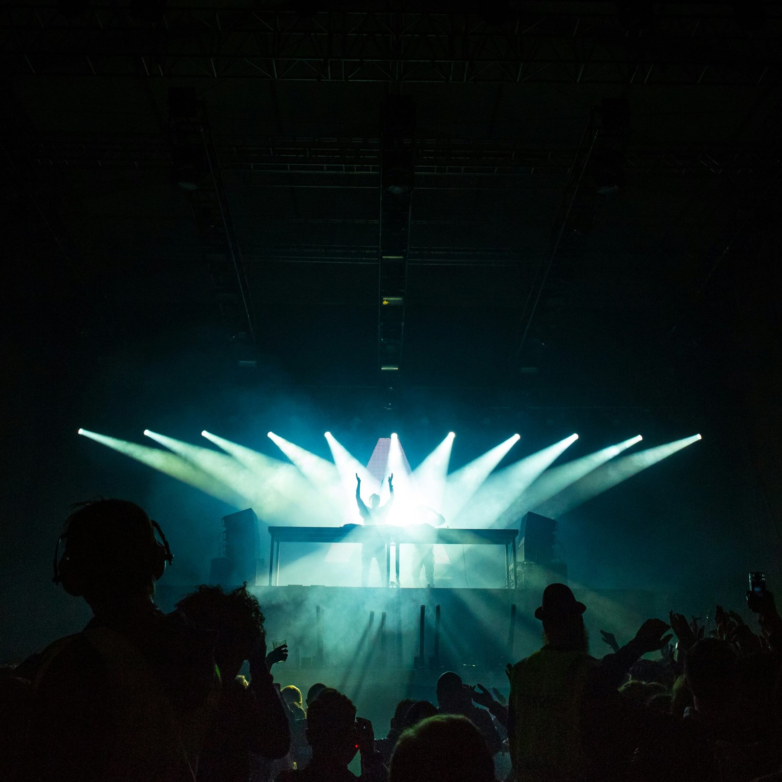 person standing under stage lights facing crowd